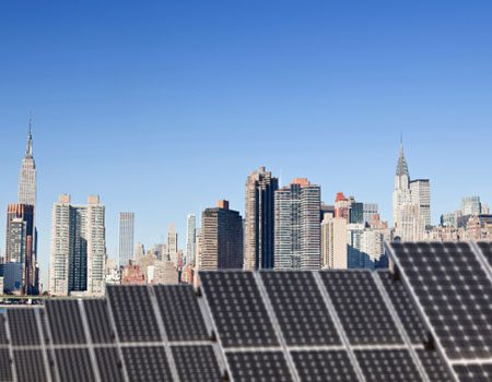 Solar panels in the foreground with the new york city skyline in the background.