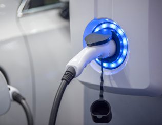 Electric vehicle charging plug connected to a charging station.